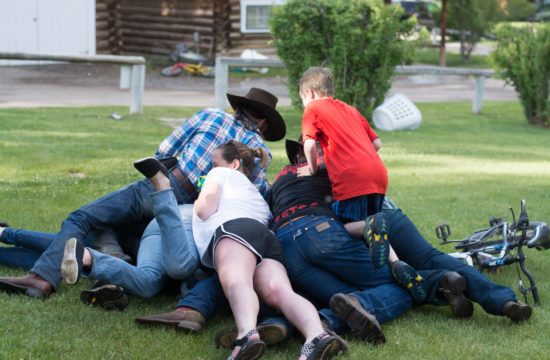 A family of ranchers pile up on each other during a playful moment