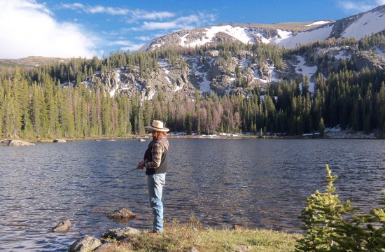 A person stands fishing along the bank of a river near CM Ranch in Dubois, WY | Wyoming dude ranch