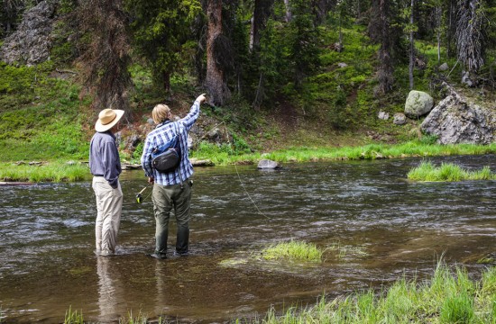 A fly fishing guide instructs a guest near CM Ranch in Dubois, WY | Wyoming dude ranch